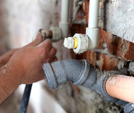 Plumber working on pipes.